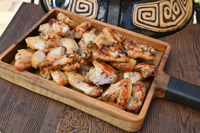 Через 15 минут волшебные куриные крылышки с золотистой корочкой, сочным мясом и потрясающим ароматом готовы — можно вынимать из тандыра!